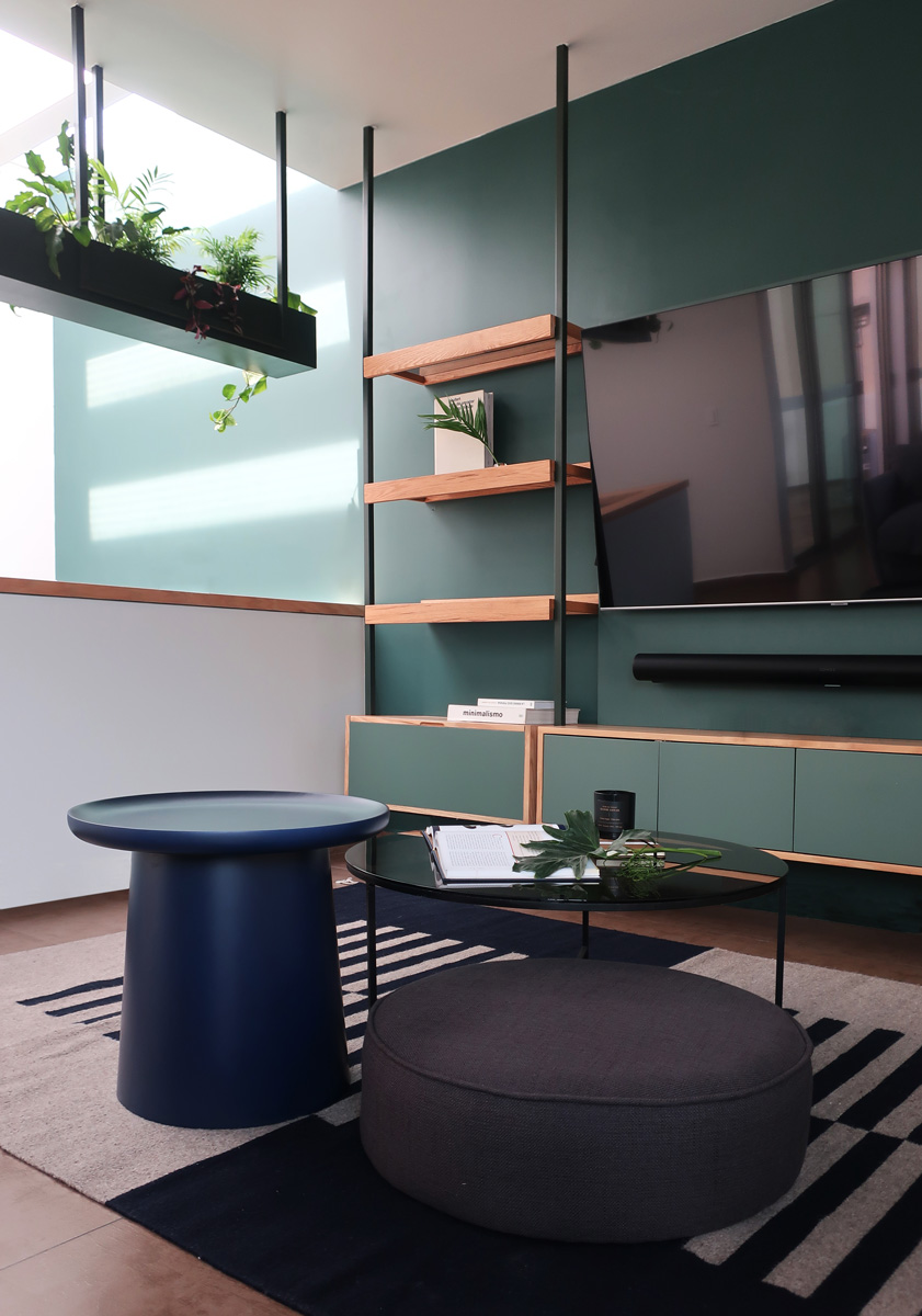 comedor de madera con base de herrería, sillas de terciopelo azul y consola de madera con herrería, cortinas y muro color azul