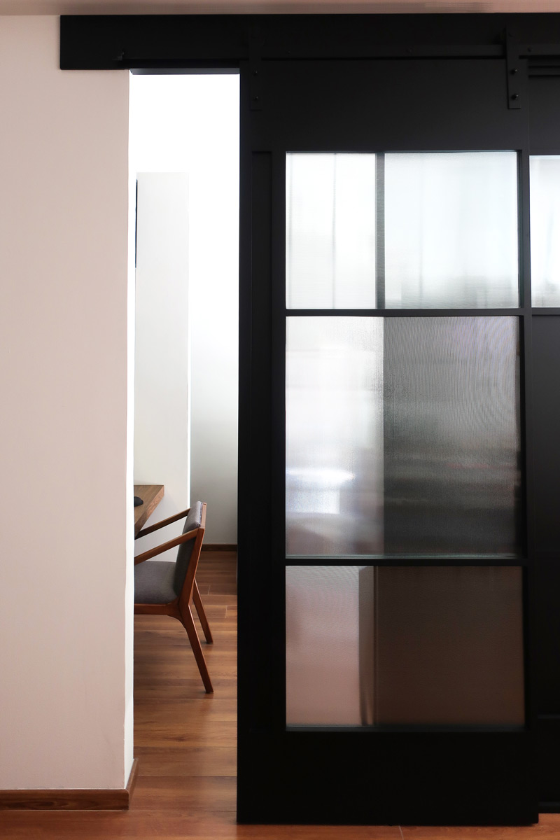 comedor de madera con base de herrería, sillas de terciopelo azul y consola de madera con herrería, cortinas y muro color azul